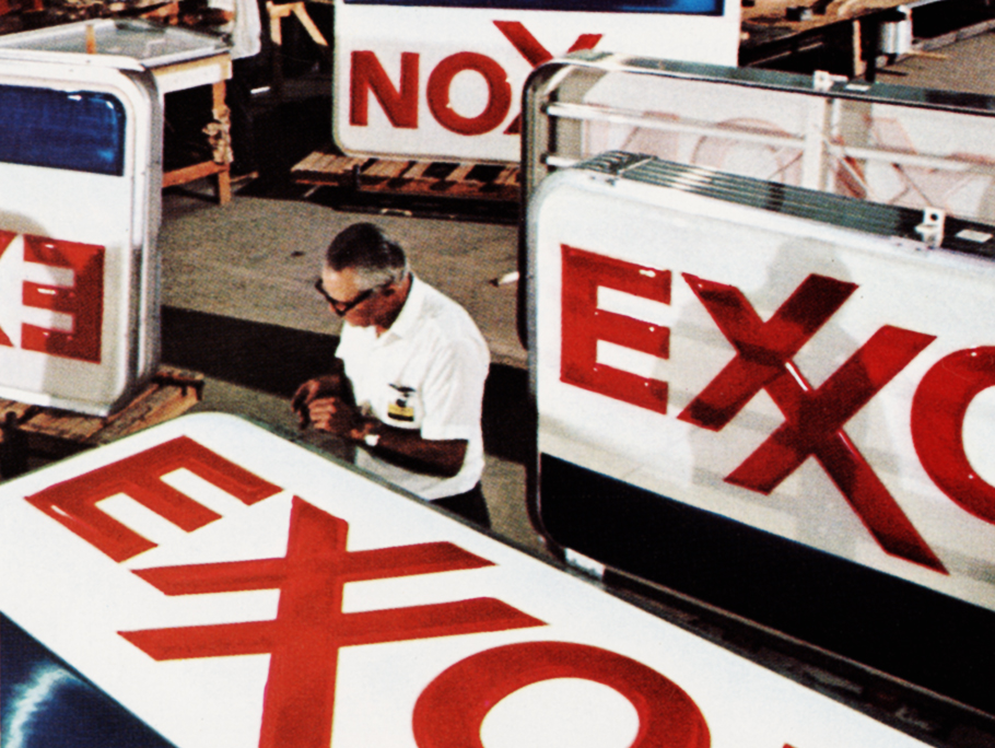Man working on ExxonMobil signs in 1972